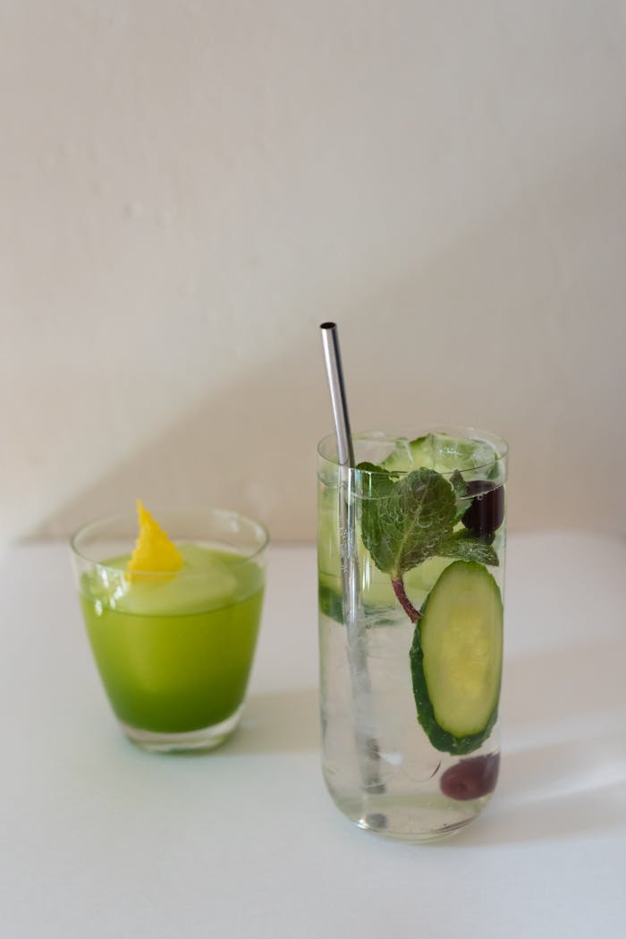 Glasses of cold drinks on white surface